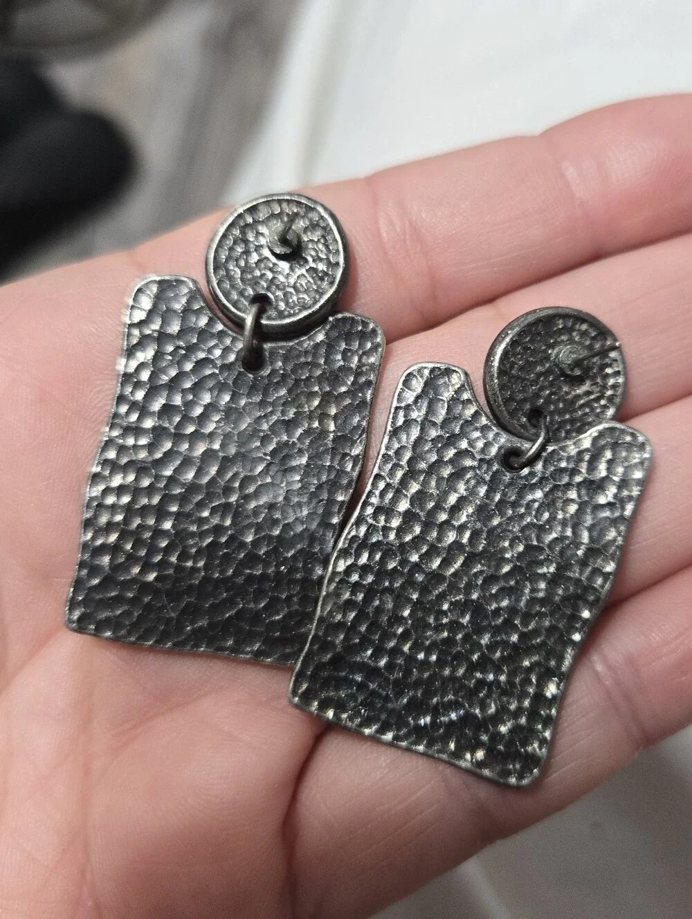 Vintage silver-tone drop earrings featuring embossed Southwestern petroglyph